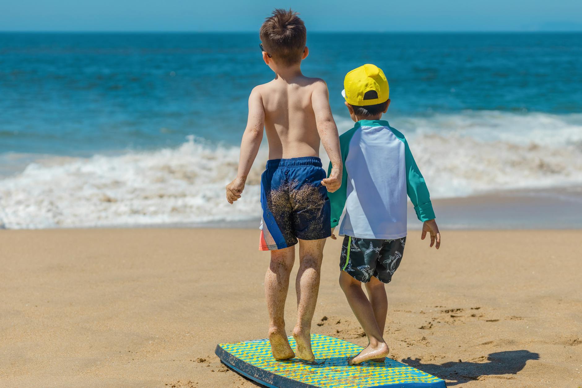 a back view of kids standing on a body board