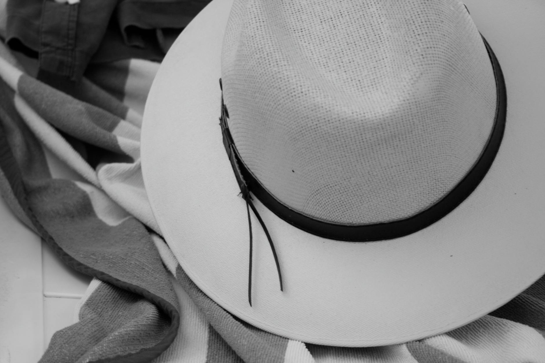 monochrome hat on striped beach towel